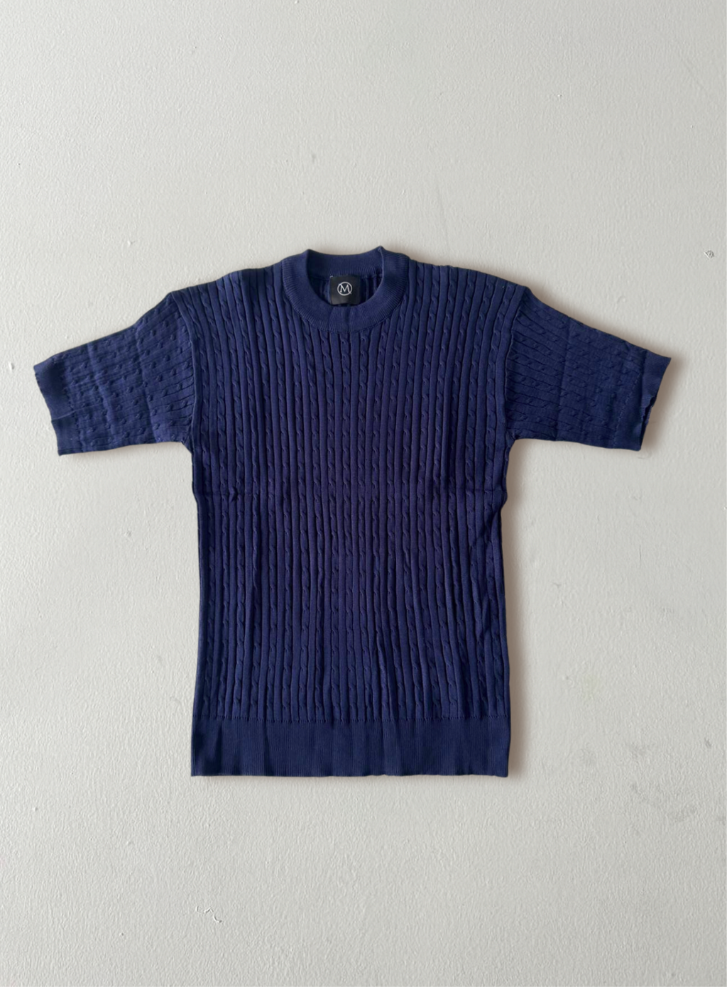 Blue ribbed sweater on a light gray background